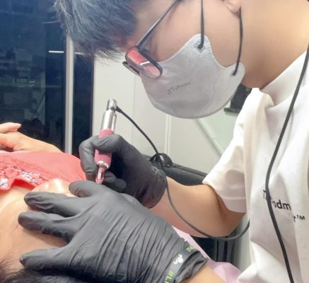 Chuyên viên đang sử dụng máy phun xăm thẩm mỹ